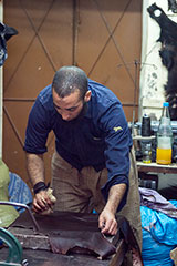 Mohammed en préparant le cuir du sac de torse en cuir pour appareil photo reflex
